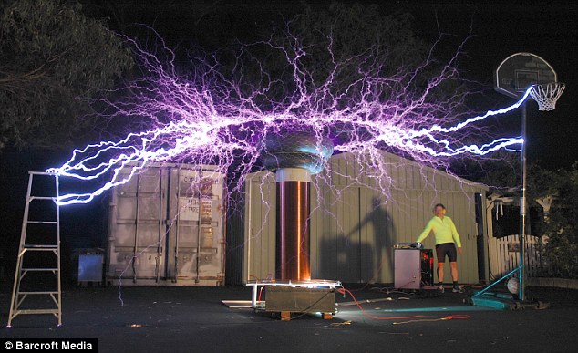 An unrelated light experiment: Australian Peter Terren stands by a sculptures, which uses a Tesla coil to generate bolts of electricity